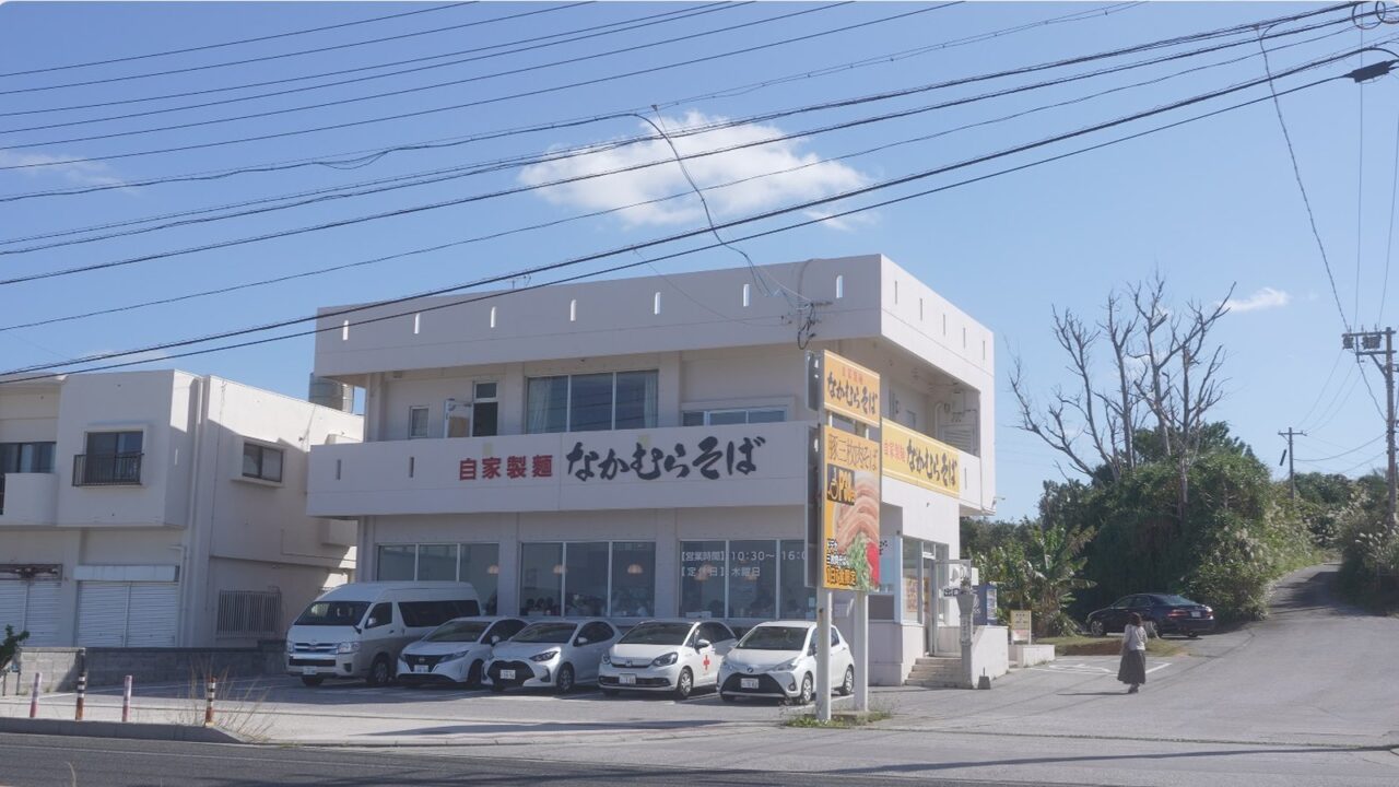 青空の下に建つ恩納村なかむらそばの店舗正面