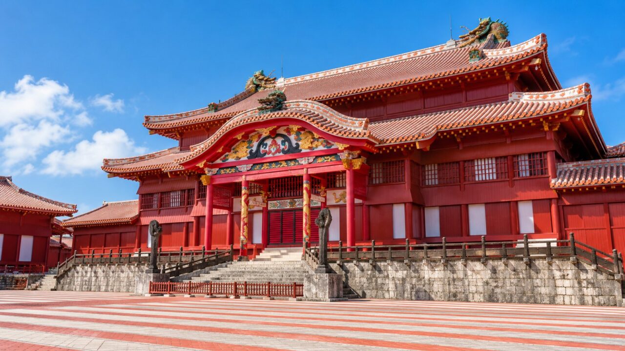 青空を背景に朱色の首里城正殿を正面から見たイメージ